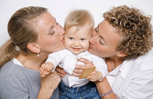 female couple kissing a child