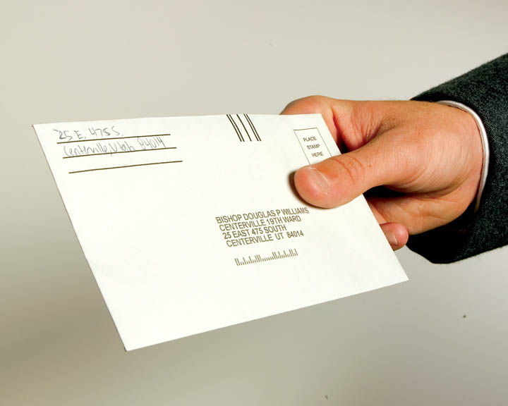 Hand Holding an LDS Tithing Envelope | Do You Pay Tithing on Social Security? | How Does Tithing on Social Security Work?